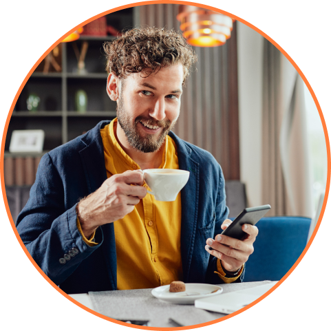 Boy smiling while drinking coffee and checking his phone